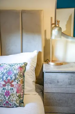 a bed with a pillow and a lamp on a nightstand at Ochil View House in Falkirk