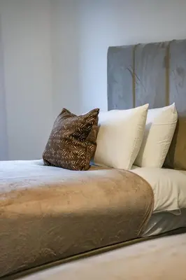 a pile of pillows sitting on a bed at Cambridge Apartment in Glasgow