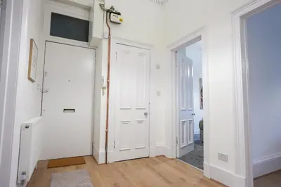 a hallway with white walls and a white door at Cambridge Apartment in Glasgow