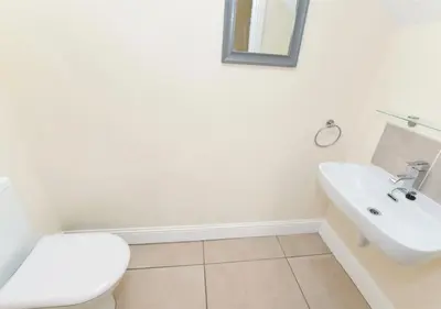 a white bathroom with a toilet and a sink at Balmore - 3 Bedroom Townhouse, heart of Killin in Killin