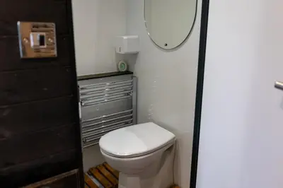 a bathroom with a toilet and a mirror at Highland Gateway Glamping in Clackmannan