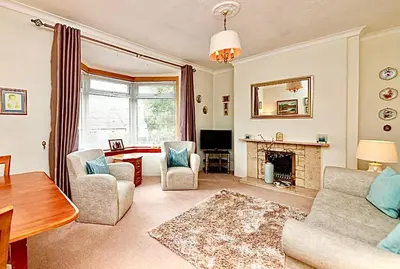 a living room with a couch and chairs and a fireplace at Cosy 2-Bed Villa in Knightswood