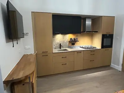 a kitchen with wooden cabinets and a sink and a counter at 77 West Princes St, cosy 1 bed ground floor in Helensburgh