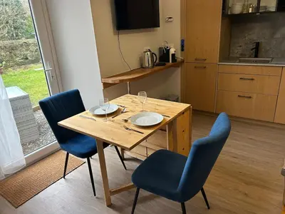 a wooden table with two plates and two chairs at 77 West Princes St, cosy 1 bed ground floor in Helensburgh