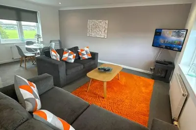 a living room with a couch and a tv at 2 Bed Apartment Sleeps 4 -Near Airport -WiFi & Tv in Renfrew