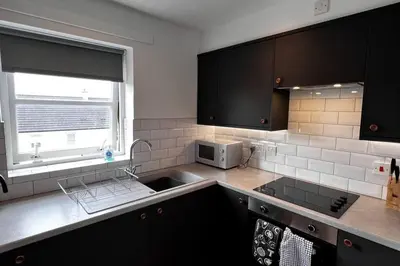a kitchen with a sink and a microwave at 2 Bed Apartment Sleeps 4 -Near Airport -WiFi & Tv in Renfrew