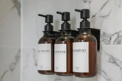 a group of three bottles of soap on a counter at The Snug - Beachwalk Apartments in Ayr