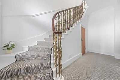 a stairway with a wooden rail and a stair case at The Snug - Beachwalk Apartments in Ayr