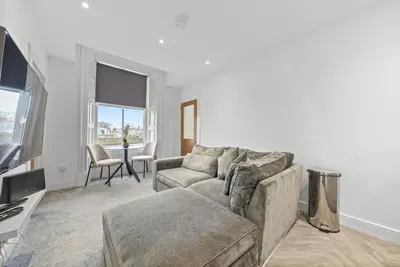 a living room with a couch and a table at The Snug - Beachwalk Apartments in Ayr
