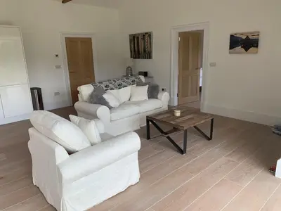 a living room with two white couches and a coffee table at The Tractor Shed- Elevated Hot Tub with Loch Views