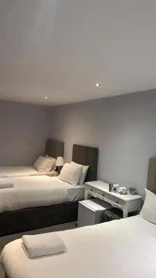 a room with two beds and a desk with two beds at Edinburgh West Residence in Edinburgh