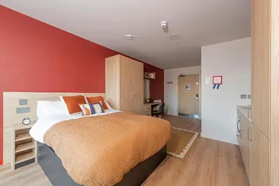 a bedroom with a bed and a red wall at For Students Only - Haymarket Yard in Edinburgh in Edinburgh