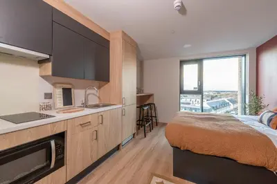 a bedroom with a bed and a kitchen with a sink at For Students Only - Haymarket Yard in Edinburgh in Edinburgh