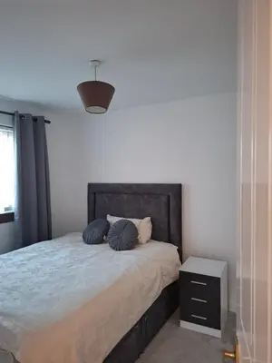 a bedroom with a bed with two pillows on it at Cheerful 3 bedroom house with free parking in Hurlet