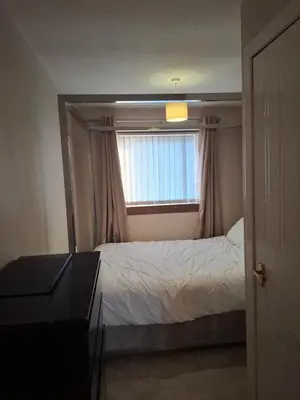 a bedroom with a bed and a window at Cheerful 3 bedroom house with free parking in Hurlet