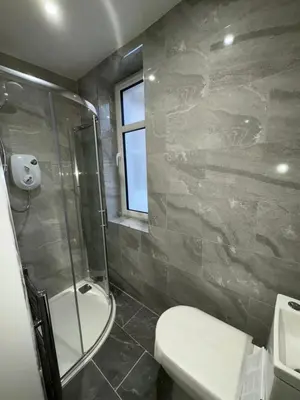 a bathroom with a shower and a toilet and a sink at Skips in Largs
