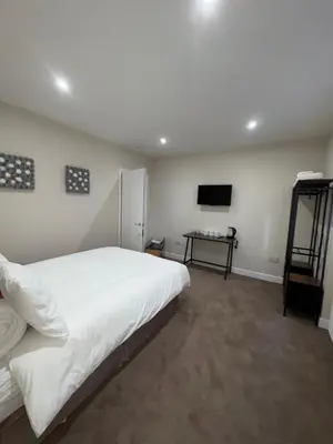 a bedroom with a large white bed and a television at Skips in Largs