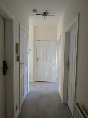 an empty hallway with white doors and tile floors at The Boswall Residence in Edinburgh