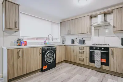 a kitchen with wooden cabinets and a black dishwasher at Dunward House in Livingston