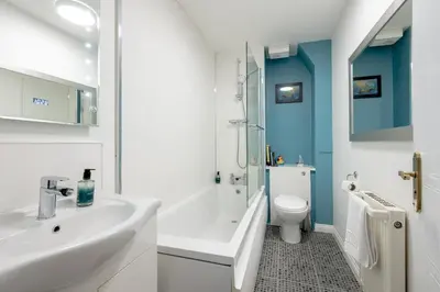 a bathroom with a white sink and a toilet at Stylish 2-Bed Flat with Balcony Near Haymarket - Pass the Keys in Edinburgh