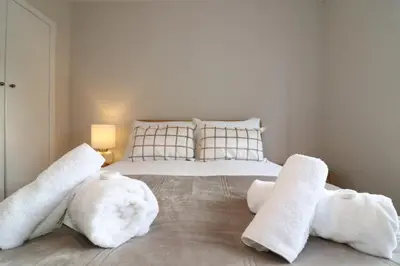 a bedroom with a bed with towels on it at Signature Greenfield House in Wishaw