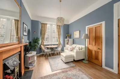 a living room with blue walls and a fireplace at Quiet 1-Bed Flat by the Meadows in Edinburgh