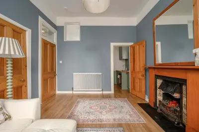 a living room with a white couch and a fireplace at Quiet 1-Bed Flat by the Meadows in Edinburgh