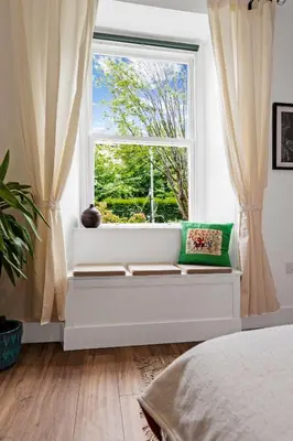 a window seat in a bedroom with a window view at Stylish 2-Bed Villa Garden Central Edinburgh in Edinburgh