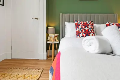 a bedroom with a large bed with colorful pillows at Stylish 2-Bed Villa Garden Central Edinburgh in Edinburgh