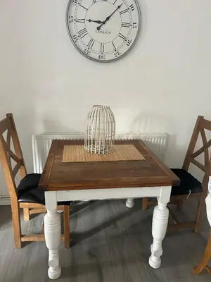 a dining room table with a clock on the wall at Rochester Cosy Comfort near Shops and Restaurant in Moffat