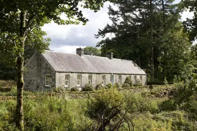 an old stone house in the middle of a field at Clachandubh Cottage in Lochgilphead