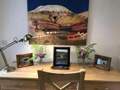 a desk with a laptop on it with a painting at Ederline Farm Cottage in Lochgilphead
