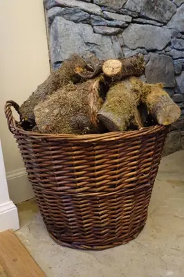 a basket full of rocks in front of a stone fireplace at School Room in Lochgilphead