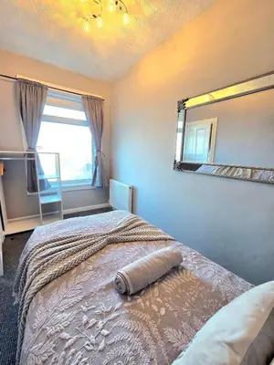a bedroom with a large bed with a large window at Bright and Cozy 3BR Home Near Hampden Park in Glasgow