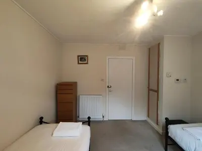 a bedroom with two beds and a hallway with a door at Fintry Inn in Fintry