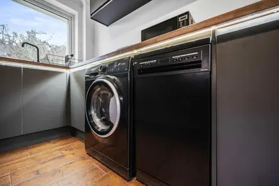 a black washer and dryer in a kitchen with a window at 2BR Oban Retreat with Free Parking in Oban