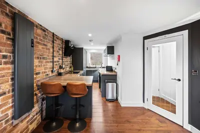 a kitchen with a brick wall and two stools at 2BR Oban Retreat with Free Parking in Oban