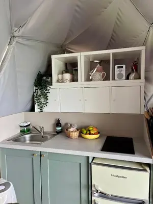 a kitchen with white cabinets and a sink in a tent at The Dome at Midauchengowan in Lochwinnoch