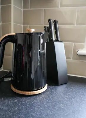 a black coffee pot on a counter with knives at Simpson House in Tillicoultry