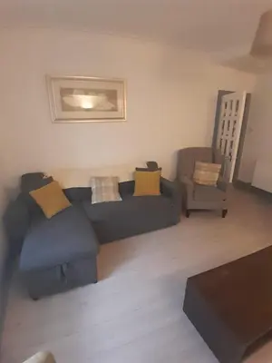 a living room with a couch and a chair at Warm Central Apartment by Meadows 7 in Edinburgh