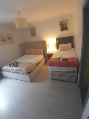 a bedroom with two beds and a lamp in it at Warm Central Apartment by Meadows 7 in Edinburgh