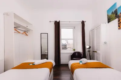 two beds in a room with a window at Calm, Cosy & Central Apartment near Meadows 10 in Edinburgh