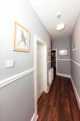 a hallway with gray walls and wooden floors at Calm, Cosy & Central Apartment near Meadows 10 in Edinburgh