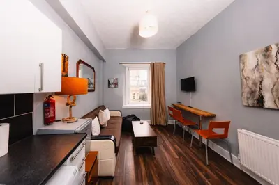 a living room with a couch and a table at Calm, Cosy & Central Apartment near Meadows 10 in Edinburgh