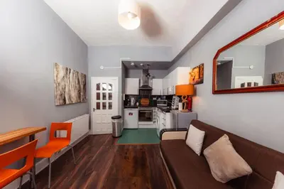 a living room with a couch and a kitchen at Calm, Cosy & Central Apartment near Meadows 10 in Edinburgh