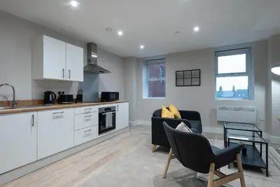 a kitchen and living room with white cabinets at Chic 1Bed in Hull City Centre near Hull College in Moffat