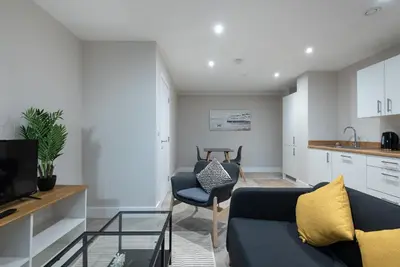 a living room with a blue couch and a kitchen at Chic 1Bed in Hull City Centre near Hull College in Moffat
