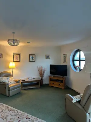 a living room with a couch and a television at Seaside Penthouse in Largs