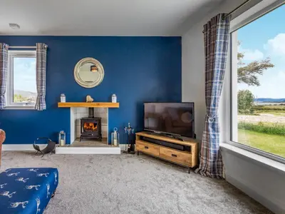 a living room with a tv and a fireplace at A'chrannchuir in Blackwaterfoot