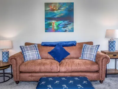 a living room with a brown couch with blue pillows at A'chrannchuir in Blackwaterfoot